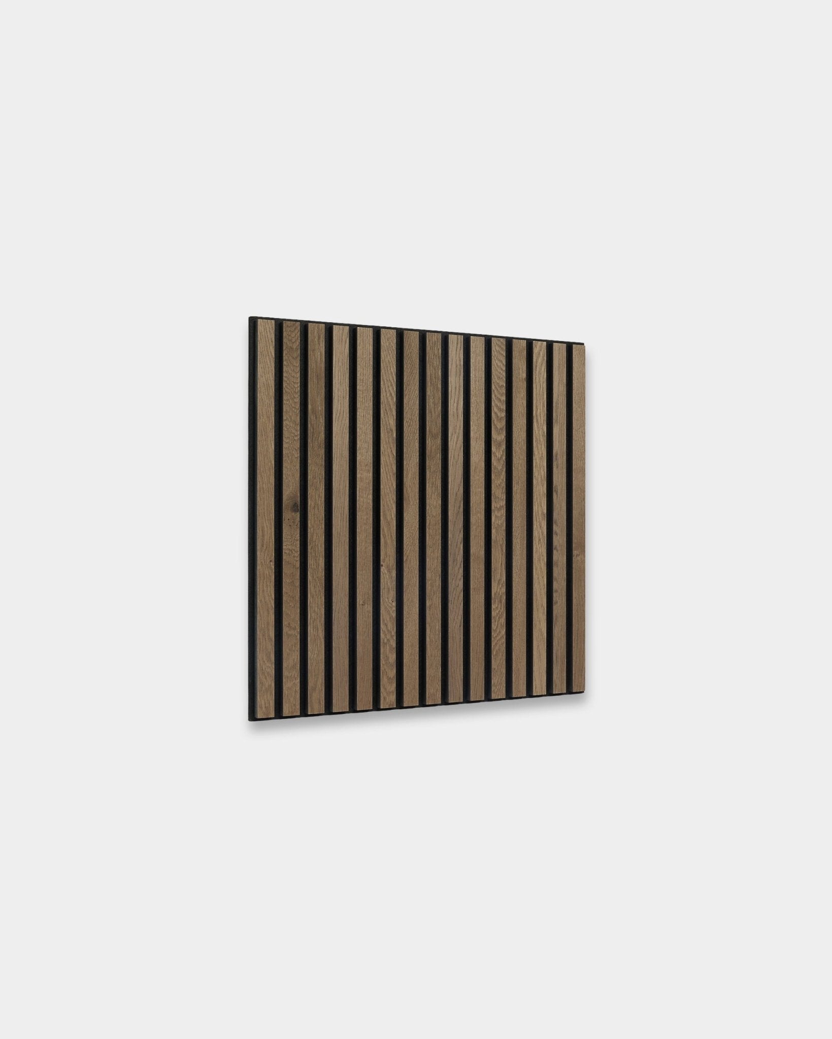 WoodUpp Akupixel Pannello acustico in grey oak, 60x60 cm, con doghe brown scure in vertical in stile scandinavo su una parete grigio chiaro.
